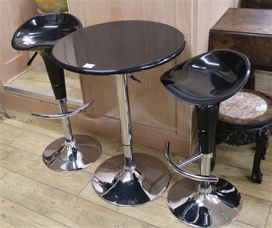 A black and chrome table and two bar stools, W.61cm